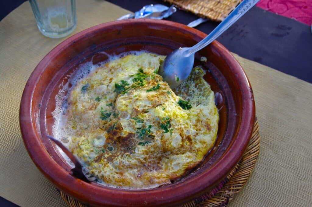 Omelette marocaine aux herbes servie dans un plat en terre cuite
