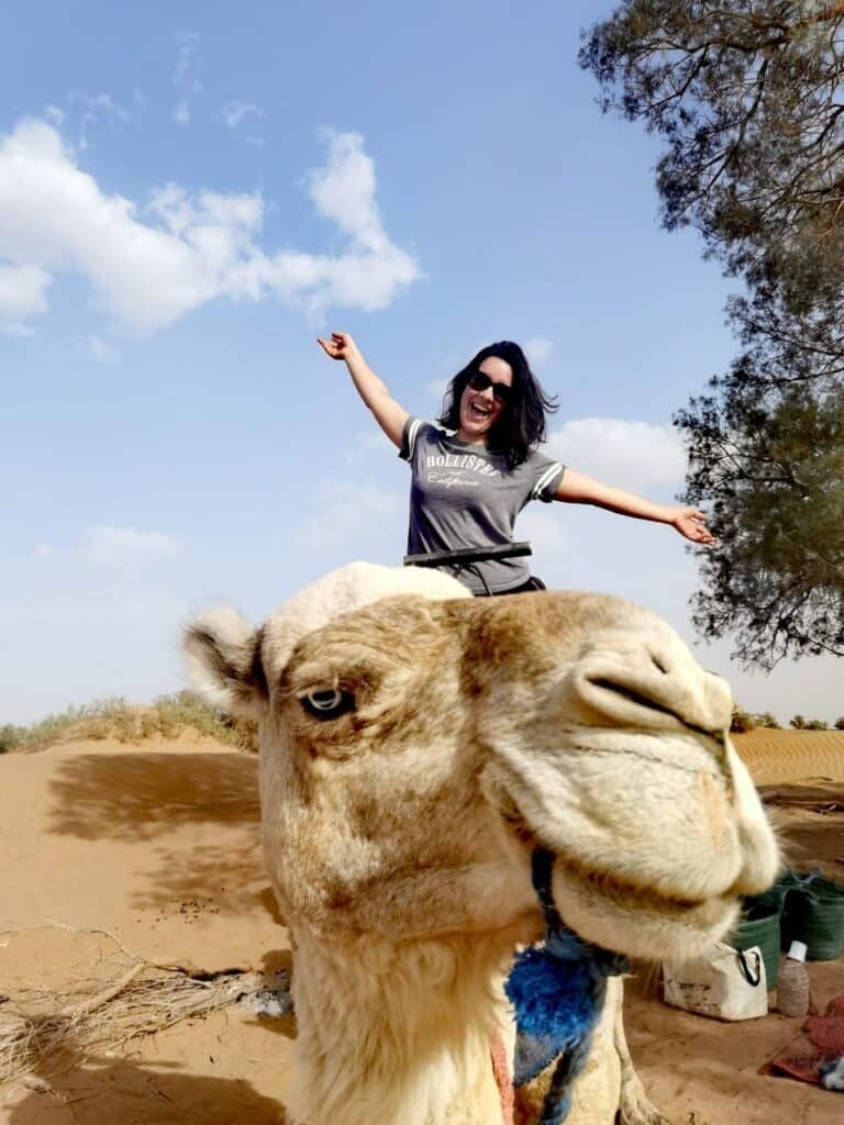 Touriste joyeuse posant en gros plan sur un dromadaire